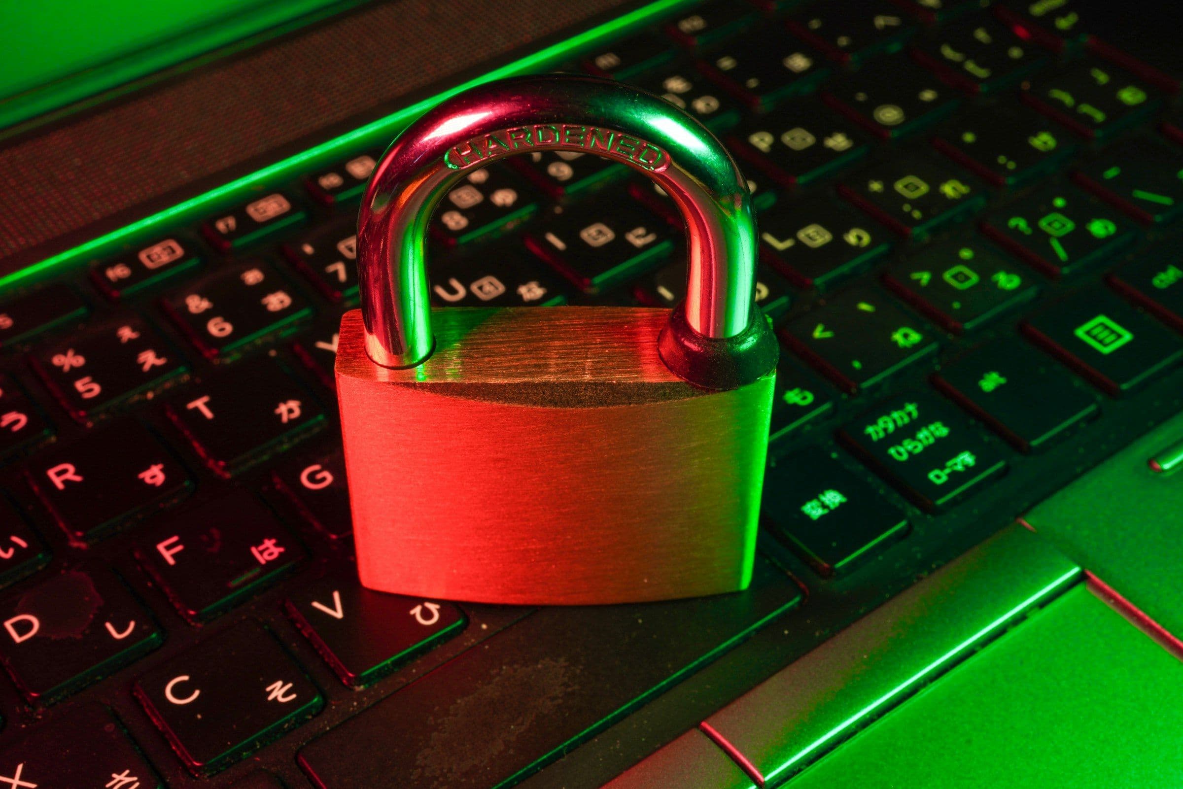 A padlock resting on a laptop keyboard lit in green, representing WordPress website security